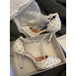 Witte damesschoenen met parelmoeren T-bandje en hoge hakken voor een bruiloft in de kerk – elegante bruidsschoenen met hakken voor een kerkelijke bruiloft