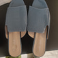 Sandalias tipo mule de piel de charol negra con punta abierta, textura de cocodrilo y tacón cuadrado, perfectas para salidas informales de verano y para la oficina.